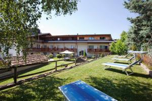 park z ławkami i budynek w tle w obiekcie Hotel Los Andes w mieście Castello-Molina di Fiemme