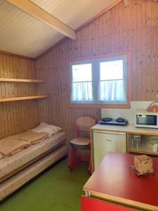 a room with a bed and a desk and a window at Camping municipal de la Lande in Nexon