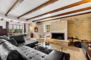 a living room with a couch and a fireplace at Villa Olea Mare with Private Heated Pool in Buici