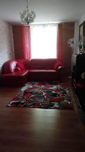 a living room with a red couch and a rug at Pokoje Gościnne Na Górach in Kazimierz Dolny