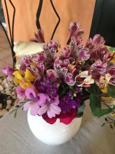 um vaso branco cheio de flores sobre uma mesa em Pension Aretoussa em Pitsidia