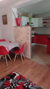 a kitchen and dining room with a table and red chairs at Pokoje Gościnne Na Górach in Kazimierz Dolny