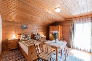 a log cabin bedroom with a bed and a table at Ferienwohnung Hartlgut in Bad Hofgastein