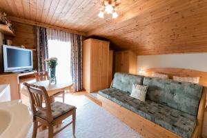 a living room with a couch and a television at Ferienwohnung Hartlgut in Bad Hofgastein