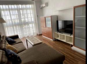 sala de estar con sofá y TV de pantalla plana en Excelente piso en San Fernando, en San Fernando