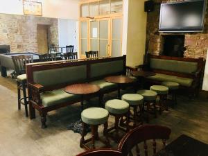 特霍西爾的住宿－Thornhill Inn，酒吧设有桌子、凳子和电视