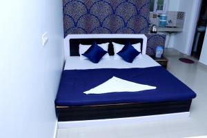 a bed with blue and white sheets and blue pillows at Himalayan Homestay in Dharamshala