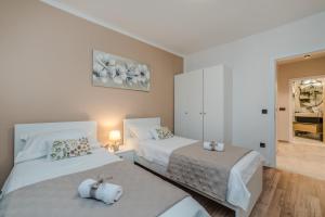 - une chambre avec 2 lits et des serviettes dans l'établissement Holiday House Paula, à Privlaka