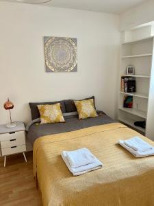 a bedroom with two beds with towels on them at 2 bedroom near Euston, King's Cross in London