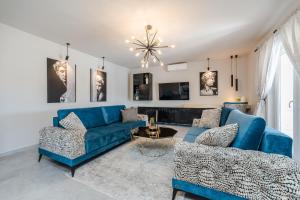- un salon avec un canapé bleu et deux chaises dans l'établissement Holiday House Paula, à Privlaka