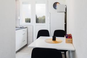 a white kitchen with a table with a hat on it at Studio apartman Sirius in Slunj