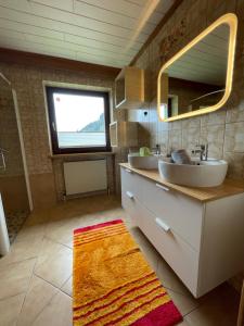 Baño con 2 lavabos y espejo en Landhaus Sonne, en Maishofen
