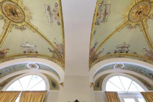 ナポリにあるIl Salotto della Reginaの天井の時計付きの建物