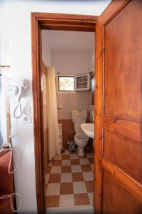 a small bathroom with a toilet and a refrigerator at Maria Nik Psaras House in Kalymnos