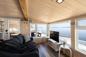 ein Wohnzimmer mit einem Sofa und einem TV in der Unterkunft Les Chalets Tourisma - Loft au bord du fleuve - La Cabine in Lotbinière