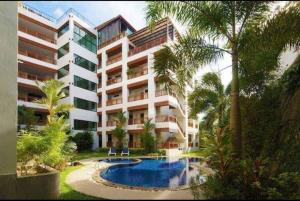 スリンビーチにあるPrivate pool apartment with 2 bedroomsのヤシの木とスイミングプールのある大きなアパートメントです。