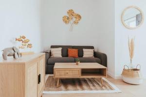 a living room with a couch and a coffee table at CAP VERT - Appartement Cocooning Chic in Saint-Étienne