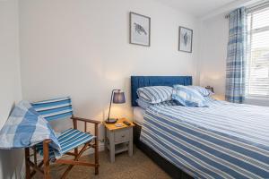 a small bedroom with a bed and a chair at Saltwhistle Beach- Couples Retreat in Teignmouth