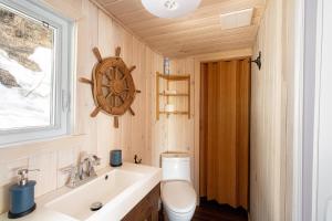 uma casa de banho com um WC, um lavatório e uma janela em Les Chalets Tourisma - Loft au bord du fleuve - La Cabine em Lotbinière