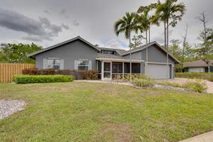 a house with palm trees in front of a yard at Spacious Wellington Vacation Rental - Private Pool in Wellington