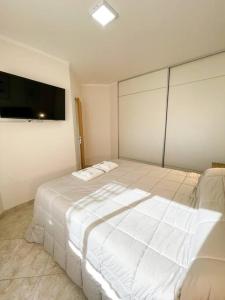 - une chambre avec un grand lit blanc et une télévision à écran plat dans l'établissement Saavedra 118 3°J by depptö, à Bahía Blanca