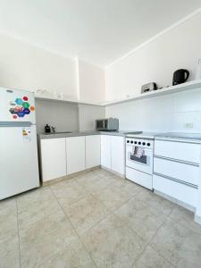 La cuisine est équipée de placards blancs et d'un réfrigérateur blanc. dans l'établissement Saavedra 118 3°J by depptö, à Bahía Blanca