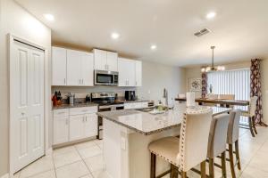 a kitchen with white cabinets and a table with chairs at Ruskin Vacation Rental with Screened-In Porch! in Ruskin