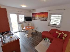 a living room with a red couch and a table at Splendid Sea View Apartment Marko in Novalja