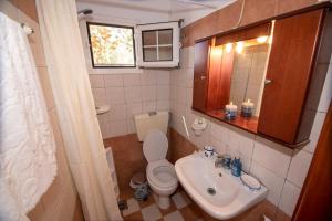 a small bathroom with a toilet and a sink at Maria Nik Psaras House in Kalymnos