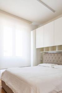 um quarto branco com uma cama grande e armários brancos em Bilocale vista sul Duomo di Milano em Milão