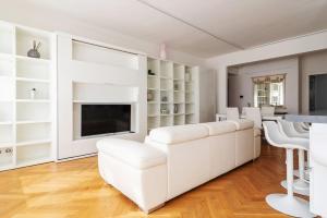 uma sala de estar com mobiliário branco e uma televisão em Bilocale vista sul Duomo di Milano em Milão