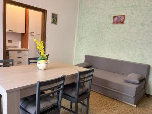 ein Esszimmer mit einem Tisch und einem Sofa in der Unterkunft Sole in Rimini