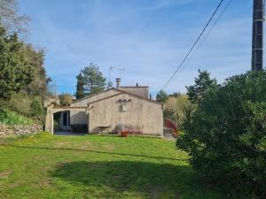 an old stone house with a yard in front of it at La Maison d'Estrella in Moussoulens