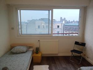 a bedroom with two beds and a large window at Le Panoramique in Bourges