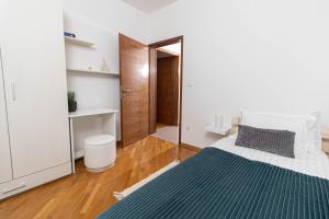 a bedroom with a bed with a blue blanket at Apartman Via Casa in Vinkovci
