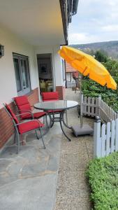 a patio with a table and chairs and an umbrella at Ferienwohnung Haus Sommerberg in Leonhardshof