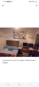 um quarto com uma cama, uma mesa e cadeiras em Cosy room in thornton heath em Thornton Heath