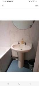 ein Badezimmer mit einem Waschbecken, einem Spiegel und einer Badewanne in der Unterkunft Cosy room in thornton heath in Thornton Heath