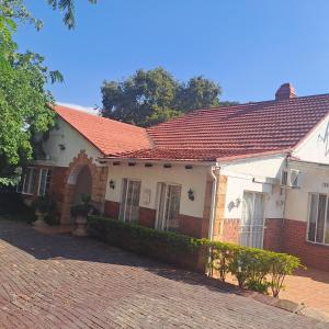 una casa con techo naranja en un camino de ladrillo en Moonlight Guesthouse en Pretoria