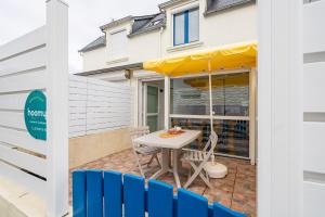 een patio met een tafel en stoelen voor een huis bij Vacances en duo au Guilvinec ! in Le Guilvinec