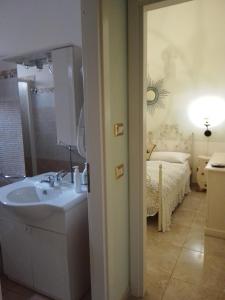 a bathroom with a sink and a bed in a room at AFFITTACAMERE A TRE MINUTI IN SPIAGGIA Il Veliero in San Vito lo Capo