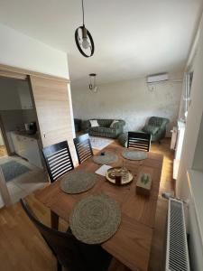 a living room with a wooden table with chairs at Apartman Didi-free parking in Novi Sad