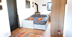 Zimmer mit einem Bett mit orangefarbenen Kissen in der Unterkunft Chalet il Palmento del Vulcano in Bronte