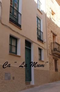 un edificio con una porta verde sul lato di CA LA MUM a Tivissa