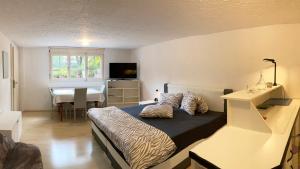 1 dormitorio con cama, escritorio y mesa en Les Ouches, en Saint-Blaise