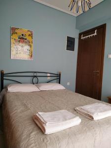 a bedroom with a bed with two towels on it at Adorable Apartment in the center in Volos