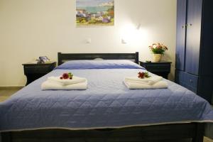 a bedroom with a blue bed with towels on it at Athina Apartments Naxos Town in Naxos Chora