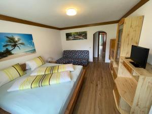 ein Wohnzimmer mit 2 Betten und einem TV in der Unterkunft Landhaus Sonne in Maishofen