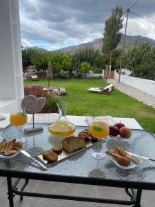 una mesa de cristal con comida y dos copas de vino en Sea and sun, en Kalamitsa