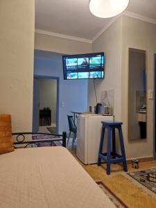 um quarto com uma cama e uma televisão na parede em Kanari em Cidade de Kos